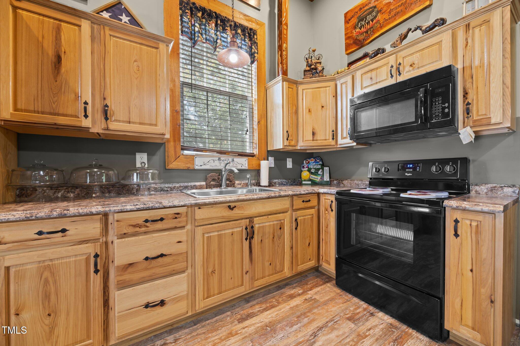 4050 Culbreth Road Stem, NC 27581 - Photo 39 of 46 a kitchen with granite countertop cabinets stainless steel appliances and a sink