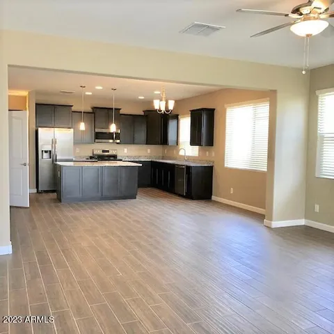 a large kitchen with a lot of counter space and wooden floor
