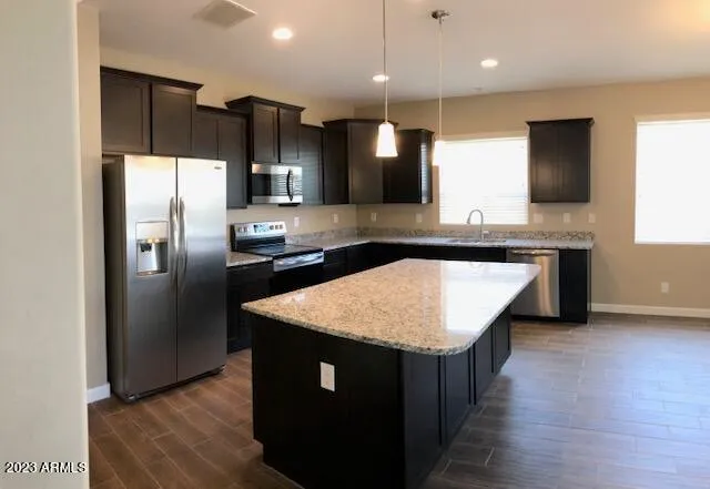 a kitchen with stainless steel appliances granite countertop a sink a refrigerator and a microwave