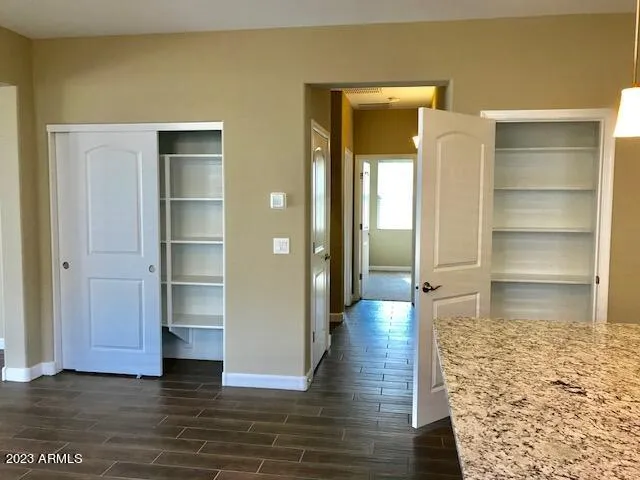 a view of a hallway with wooden floor and closet