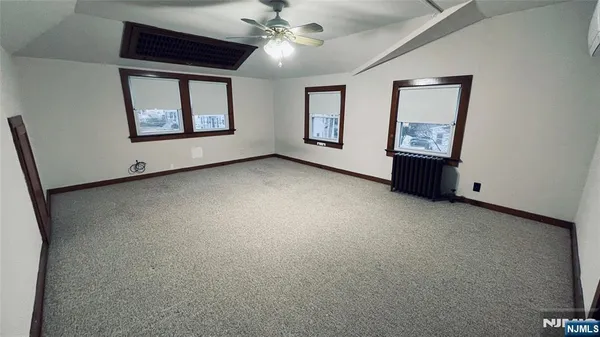 a view of an empty room with windows and closet