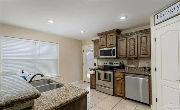 a kitchen with stainless steel appliances granite countertop a stove and a refrigerator