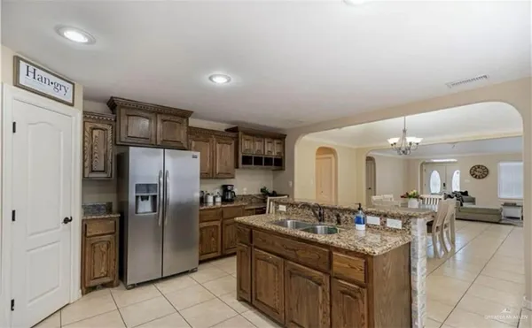 a kitchen with granite countertop a sink cabinets and stainless steel appliances