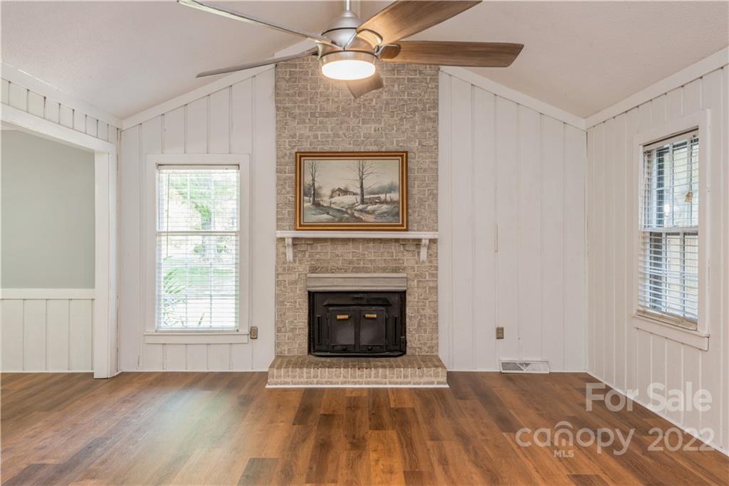 7607 Alexander Road Charlotte, NC 28270 - Photo 5 of 34 a view of an empty room with wooden floor fireplace and a window