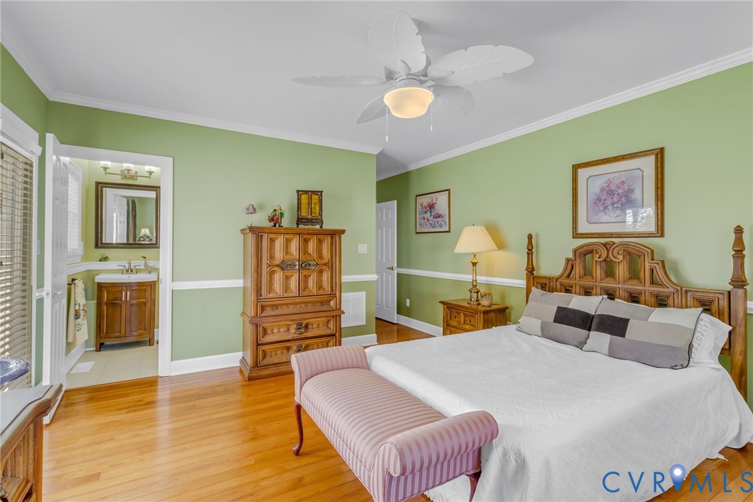 273 Sutton Avenue Reedville, VA 22539 - Photo 19 of 50 a bedroom with a bed and wooden floor