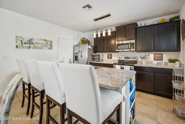 a living room with stainless steel appliances kitchen island granite countertop furniture and a kitchen view