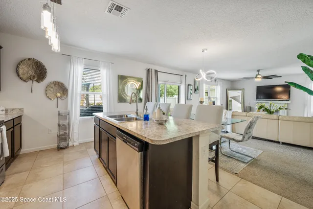 a kitchen with stainless steel appliances granite countertop a table chairs and a refrigerator