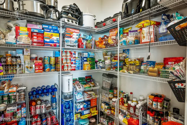 a dining hall with granite countertop a sink dishwasher and a refrigerator with white cabinets