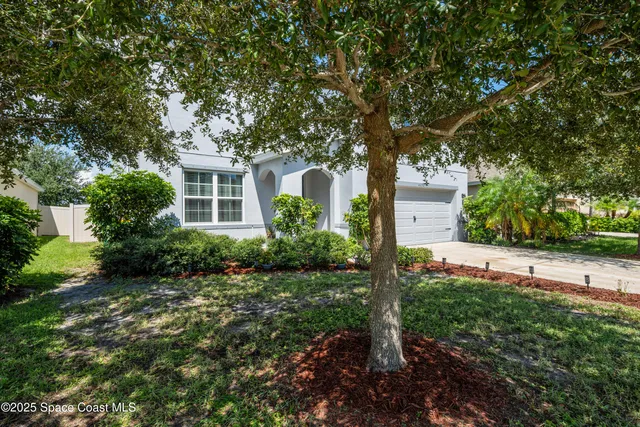 a front view of house with yard and trees