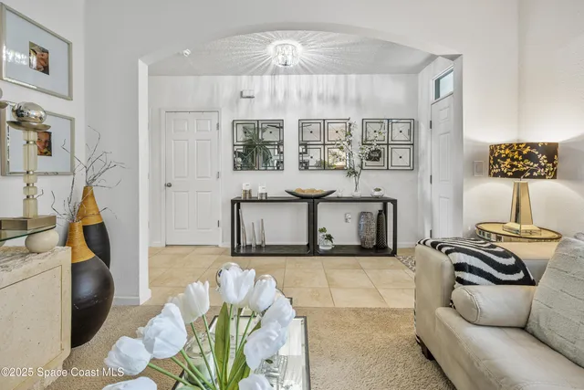 a living room with furniture a chandelier and a floor to ceiling window