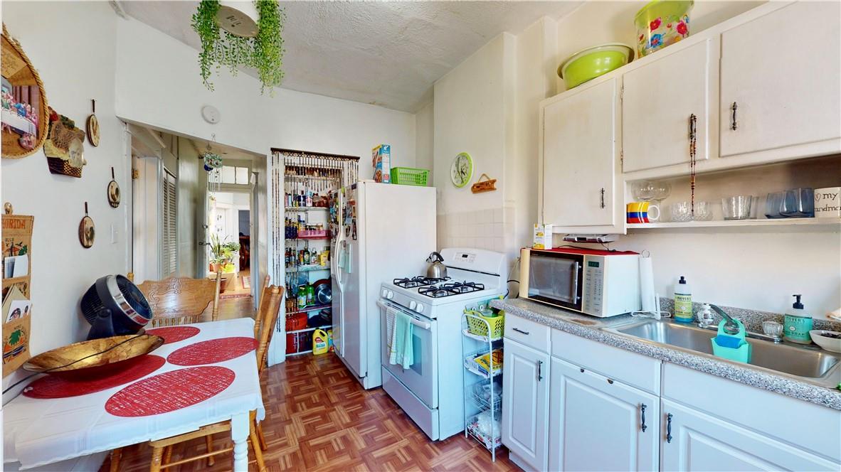 80-13 86th Road Queens, NY 11421 - Photo 7 of 18 a kitchen with a refrigerator and a stove top oven