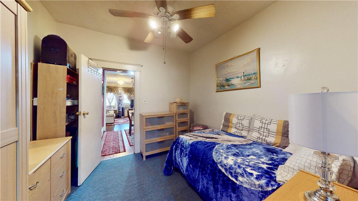 80-13 86th Road Queens, NY 11421 - Photo 10 of 18 a bedroom with a bed and a chandelier