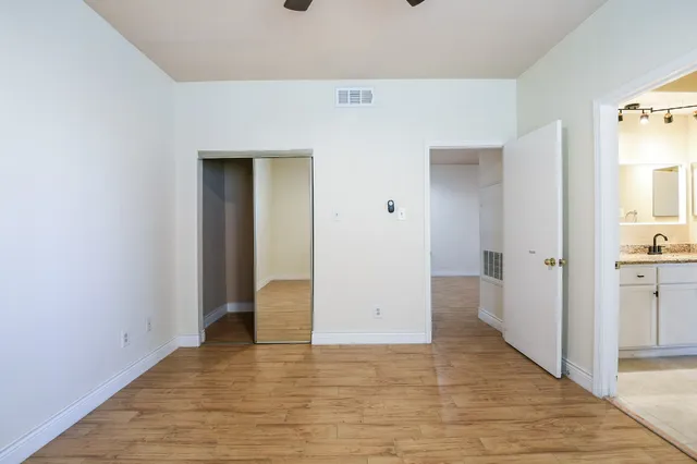 a view of a hallway with wooden floor and closet