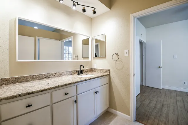 a bathroom with a granite countertop sink mirror and vanity