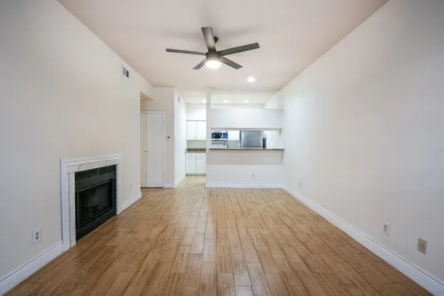 a view of a kitchen with wooden floor and a ceiling fan