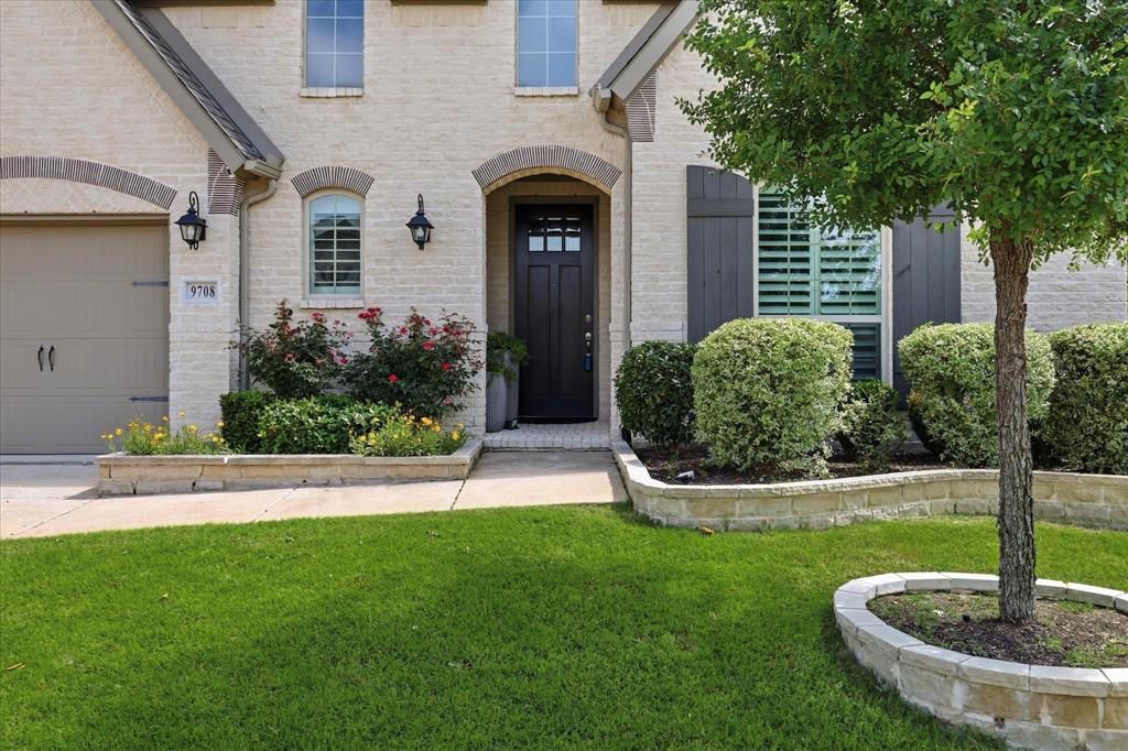 9708 Surveyor Road Oak Point, TX 75068 - Photo 2 of 34 Light-colored brick exterior featuring an arched entryway and dark paneled front door