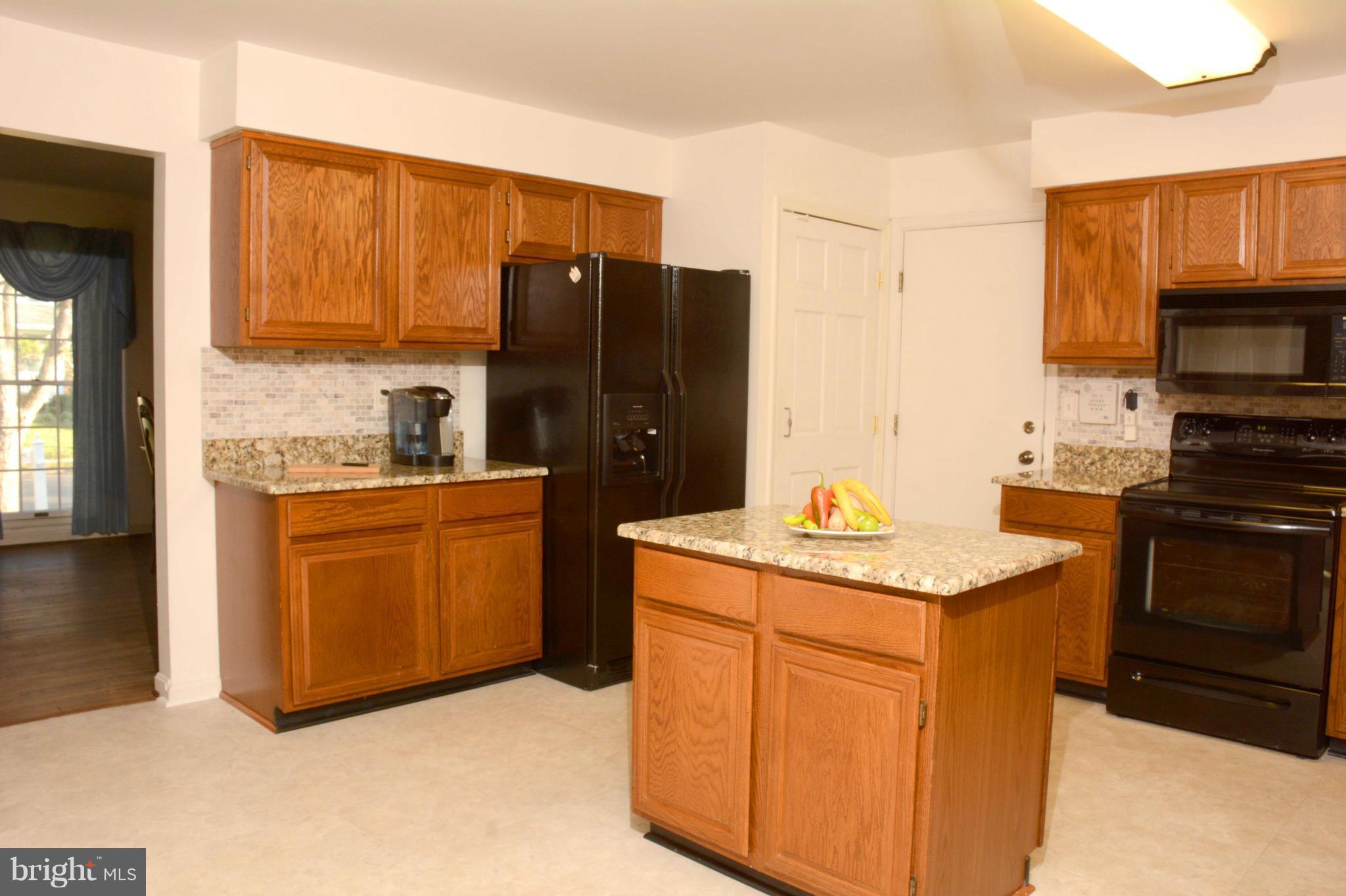 305 Riding Ridge Road Annapolis, MD 21403 - Photo 5 of 29 a kitchen with stainless steel appliances granite countertop a refrigerator a stove a sink and a microwave
