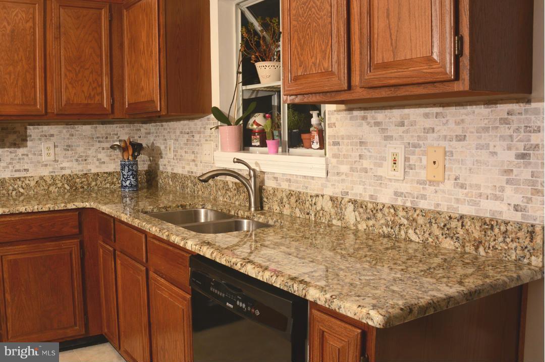 305 Riding Ridge Road Annapolis, MD 21403 - Photo 7 of 29 a kitchen with granite countertop wooden cabinets and a sink