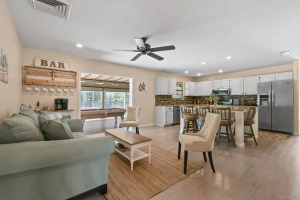 a kitchen with a dining table chairs refrigerator and cabinets