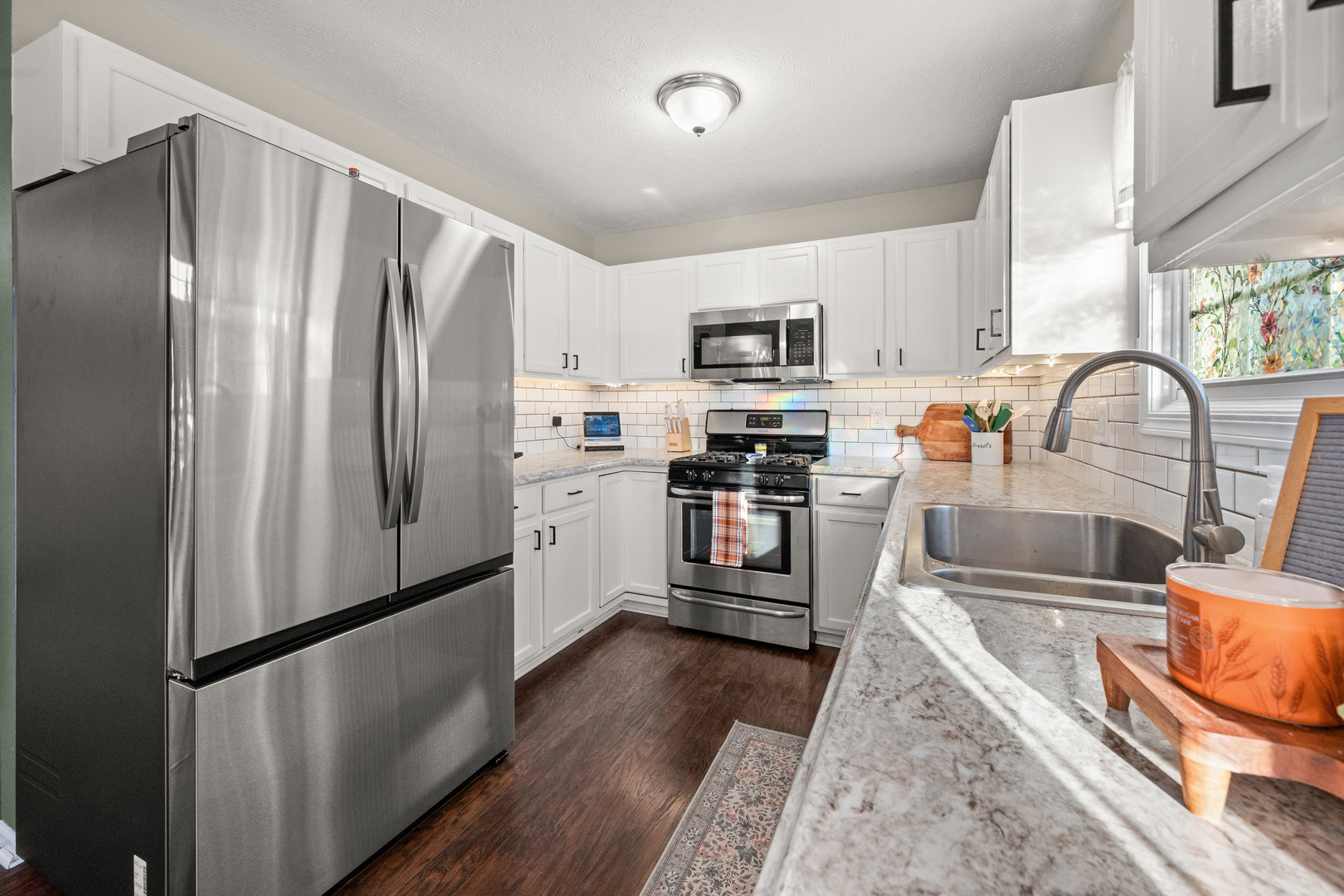 710 Hawthorne Lane Genoa, IL 60135 - Photo 8 of 24 a kitchen with stainless steel appliances granite countertop a refrigerator a stove and a sink with wooden floor
