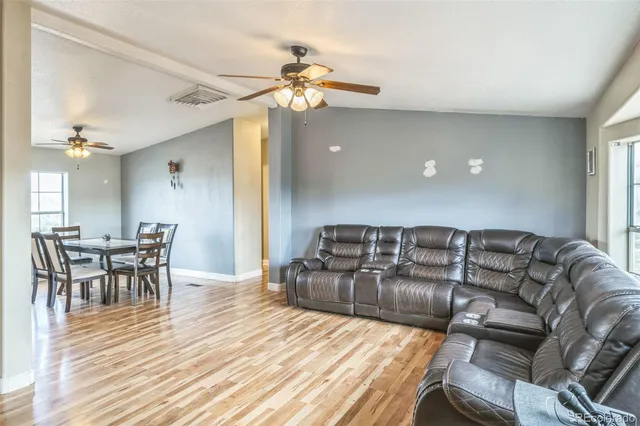 a living room with furniture and a wooden floor