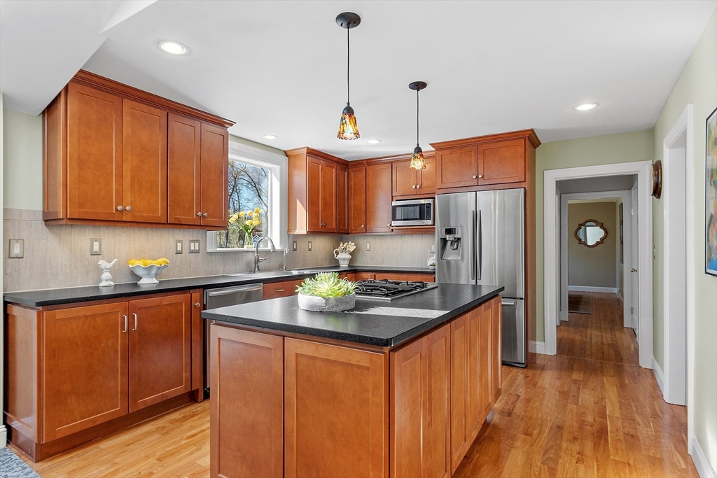 40 Bellevue Road Andover, MA 01810 - Photo 8 of 42 a kitchen with stainless steel appliances granite countertop wooden cabinets a refrigerator a sink a stove a refrigerator and island with wooden floor