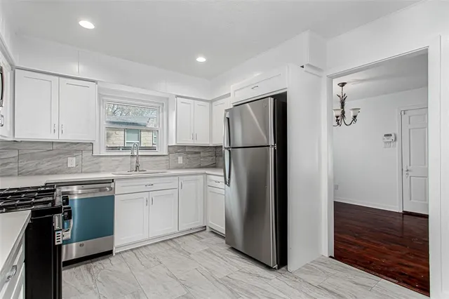 a kitchen with a refrigerator sink and cabinets