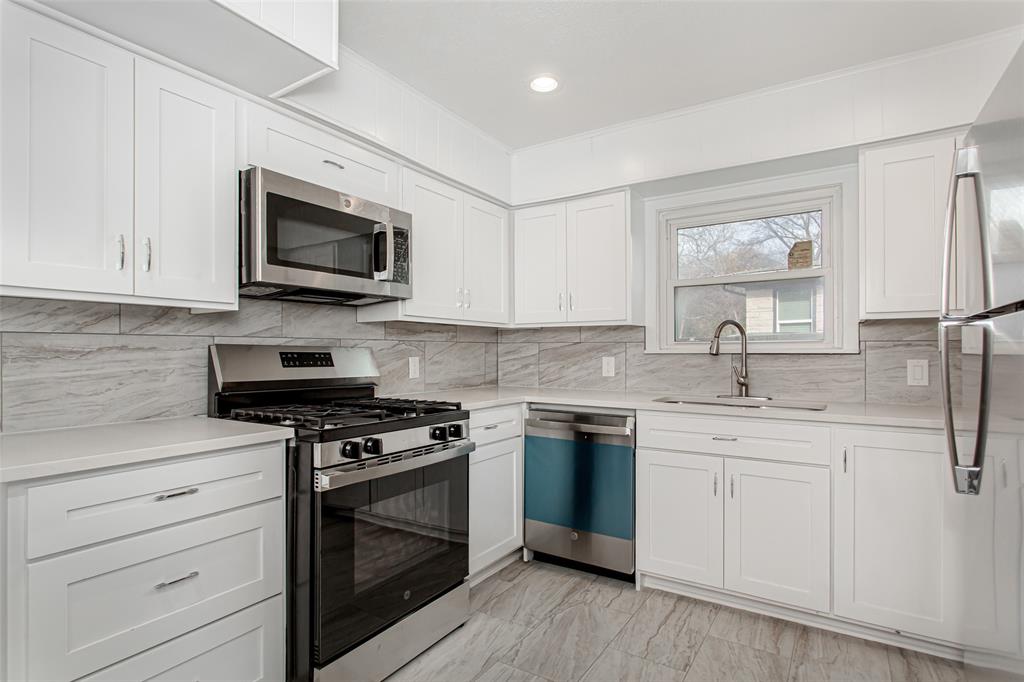 3311 Tooms Street Dallas, TX 75227 - Photo 14 of 38 a kitchen with stainless steel appliances granite countertop a stove a sink and a microwave