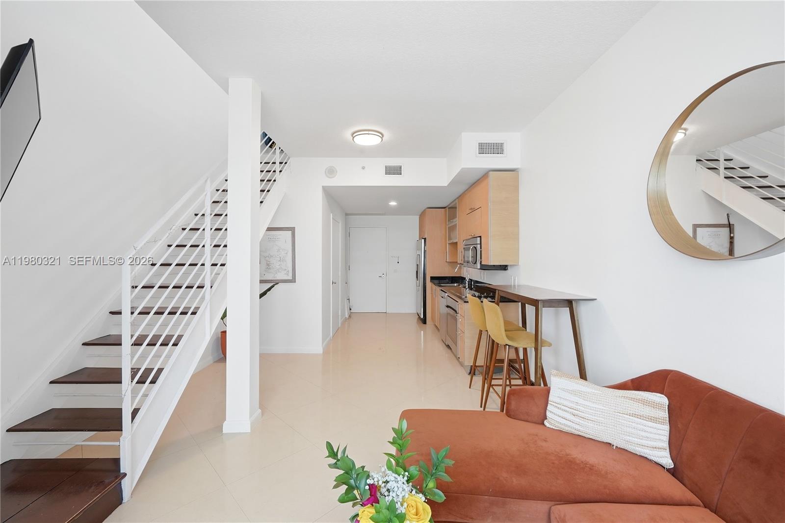 60 Southwest 13th Street, Unit 4414 Miami, FL 33130 - Photo 13 of 56 a living room with furniture and a chandelier