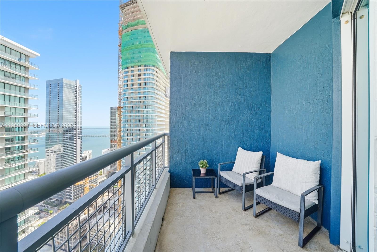 60 Southwest 13th Street, Unit 4414 Miami, FL 33130 - Photo 20 of 56 a balcony with couple of chairs and a wooden fence