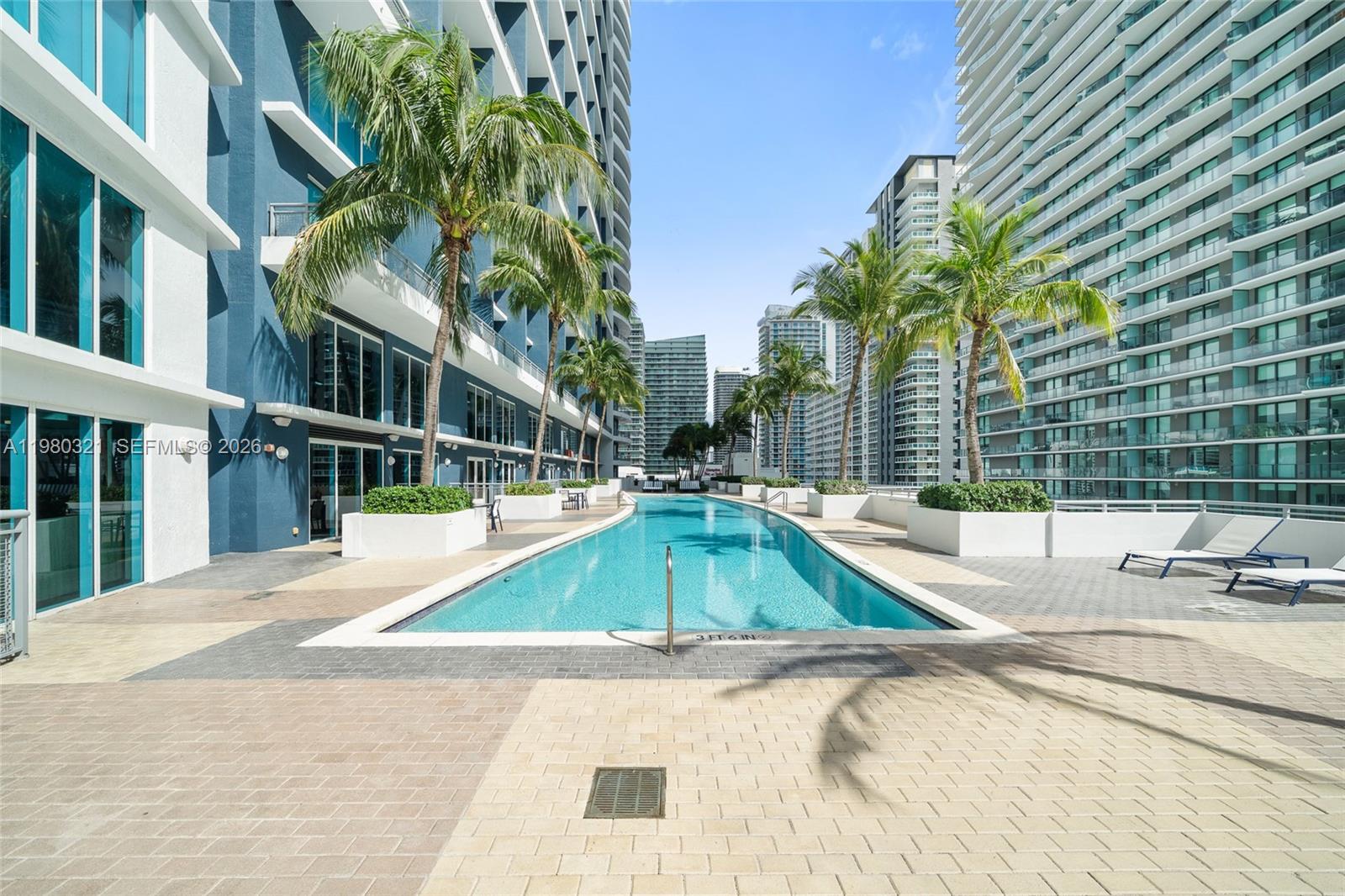 60 Southwest 13th Street, Unit 4414 Miami, FL 33130 - Photo 33 of 56 a view of a swimming pool with a lounge chairs
