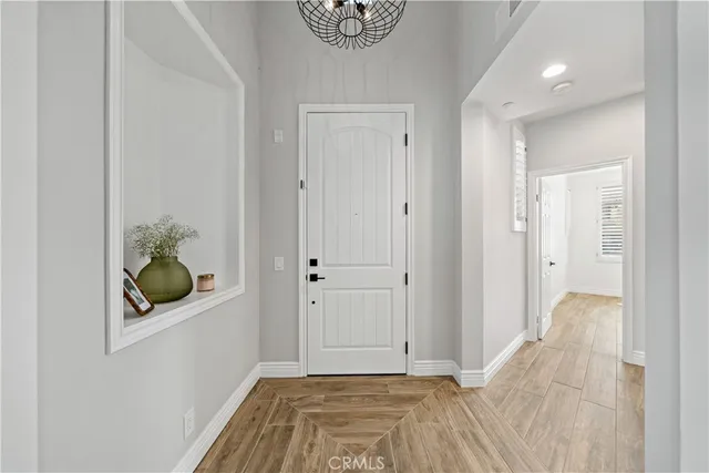 a view of hallway with window and wooden floor