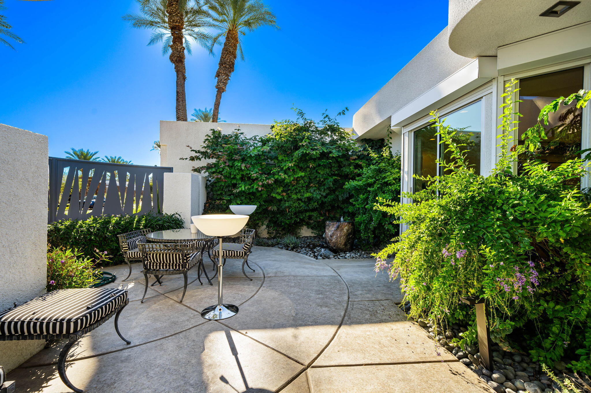 105 Waterford Circle Rancho Mirage, CA 92270 - Photo 13 of 76 a view of a chair and table in backyard of the house