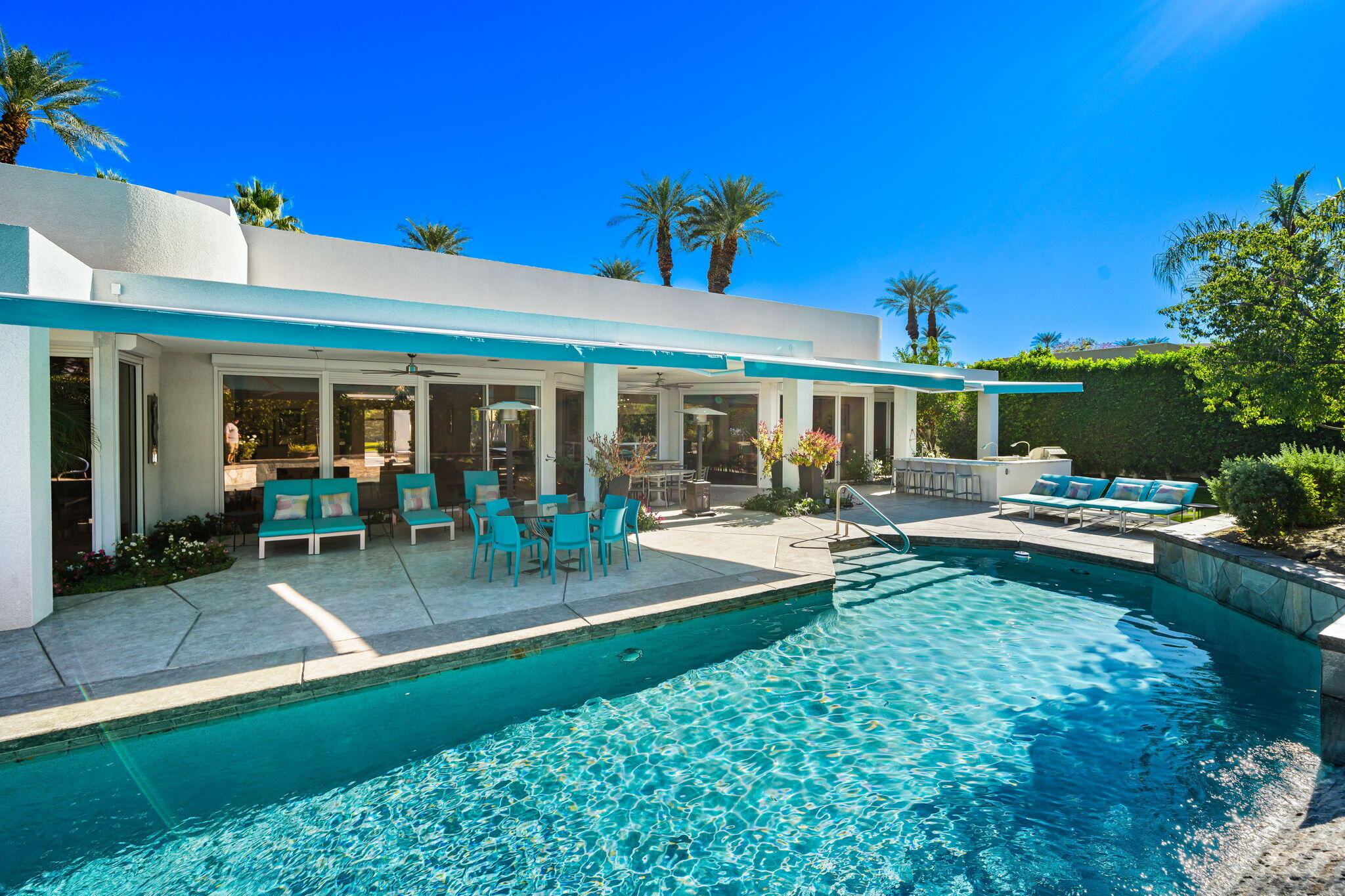 105 Waterford Circle Rancho Mirage, CA 92270 - Photo 56 of 76 a view of a patio with table and chairs potted plants and palm tree