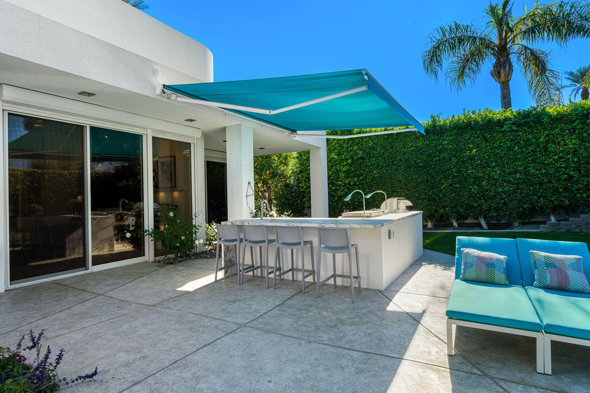 105 Waterford Circle Rancho Mirage, CA 92270 - Photo 58 of 76 a view of a patio with couches table and chairs potted plants and palm tree