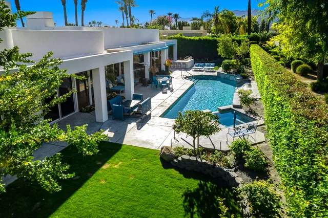 a view of a yard with plants and wooden fence