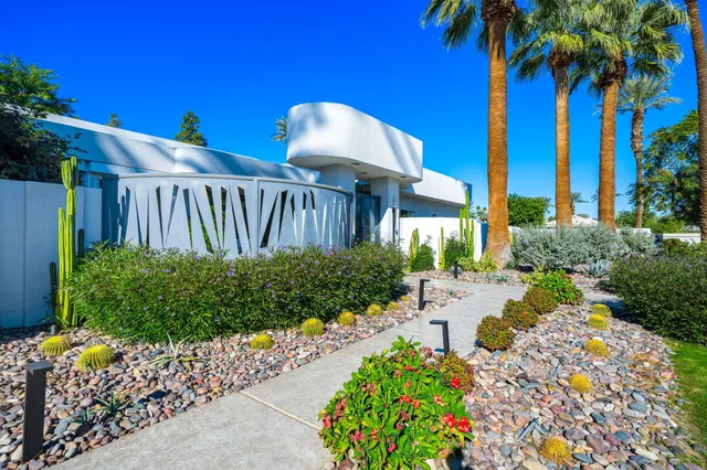a view of a house with a yard and potted plants