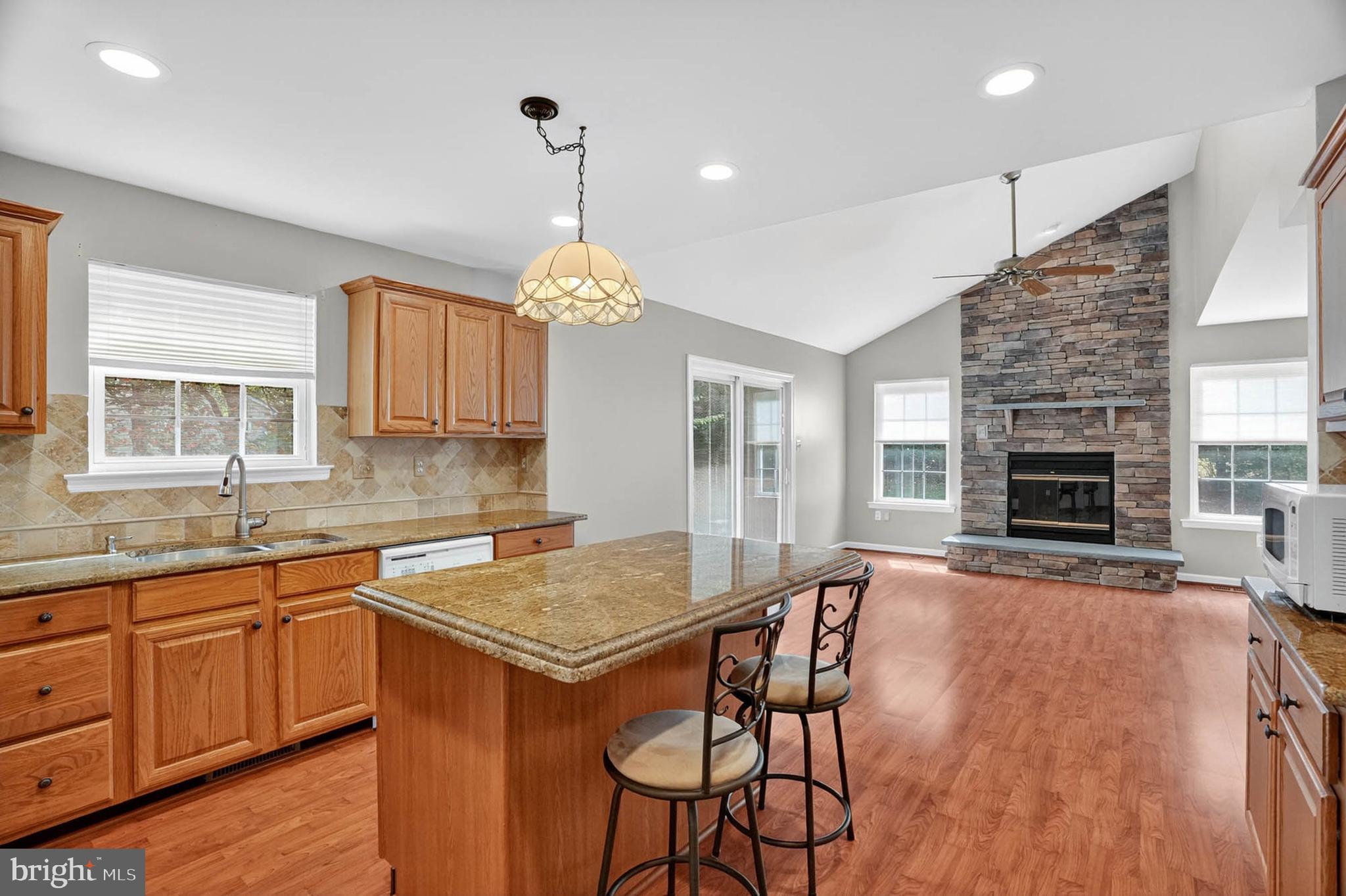 1749 Maple Avenue Hanover, MD 21076 - Photo 13 of 41 a open kitchen with stainless steel appliances granite countertop a stove top oven a sink dishwasher a dining table and chairs with wooden floor