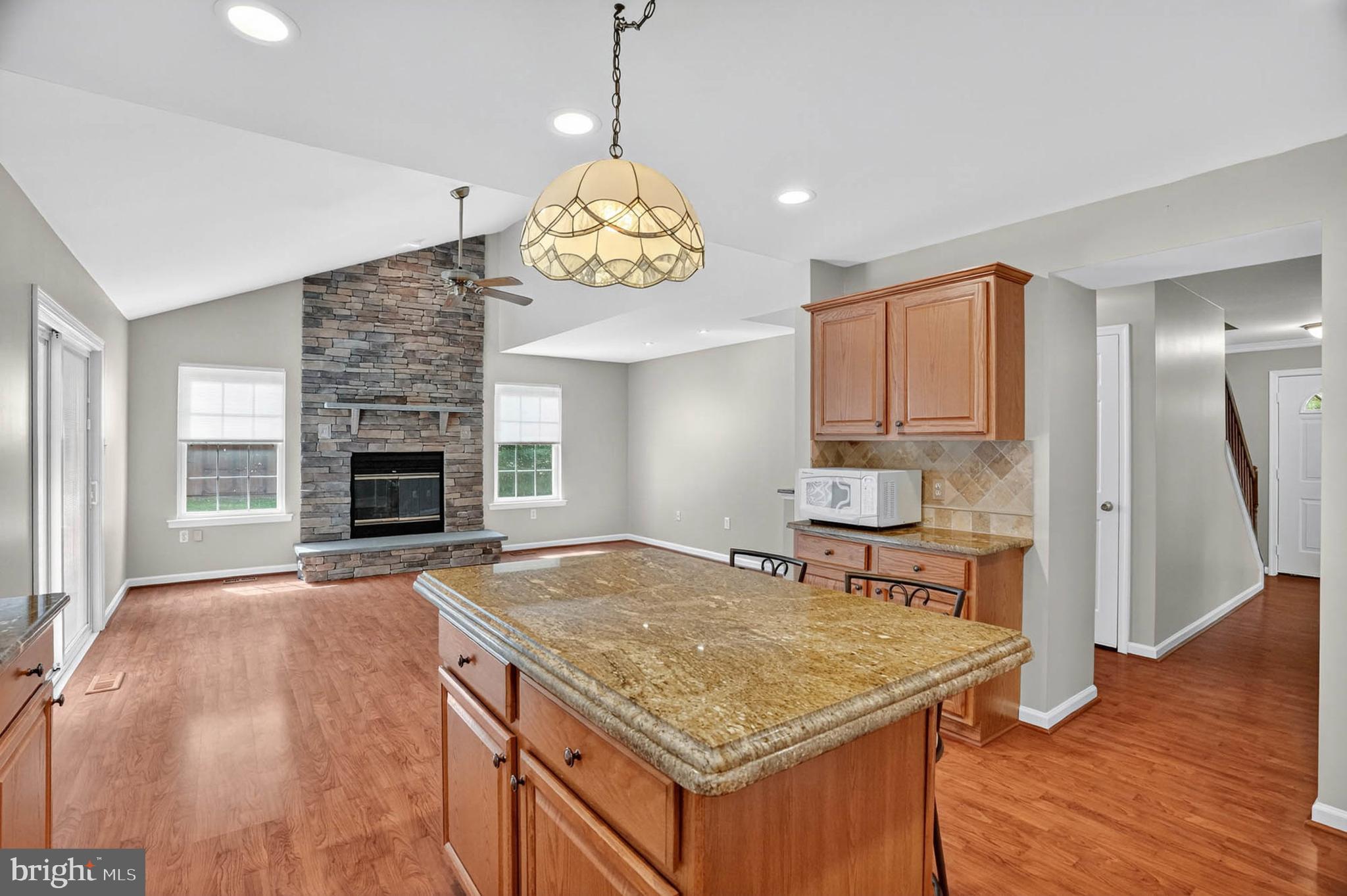 1749 Maple Avenue Hanover, MD 21076 - Photo 14 of 41 a kitchen with a stove a sink a kitchen island with wooden floor and chandelier