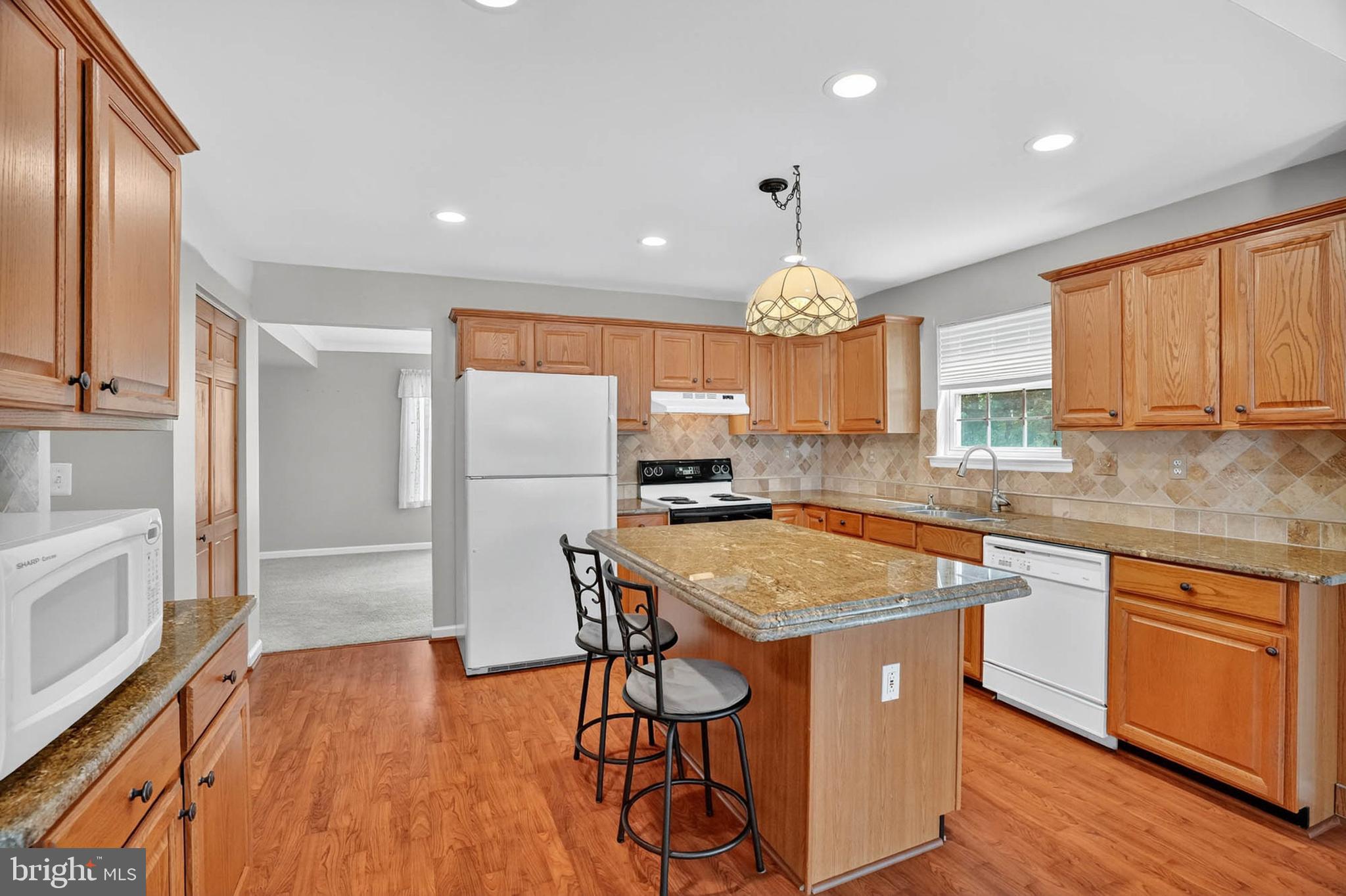 1749 Maple Avenue Hanover, MD 21076 - Photo 16 of 41 a kitchen with stainless steel appliances granite countertop wooden floors and white cabinets