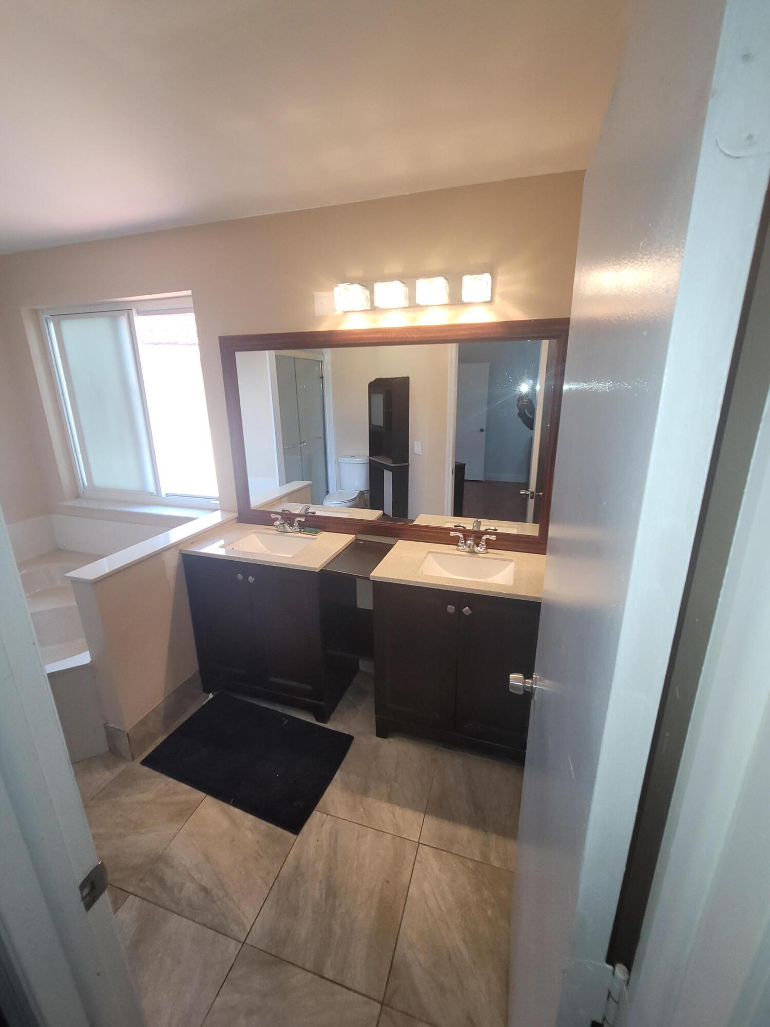 8448 Northwest 196th Terrace Hialeah, FL 33015 - Photo 17 of 67 a bathroom with a sink a mirror and a bathtub