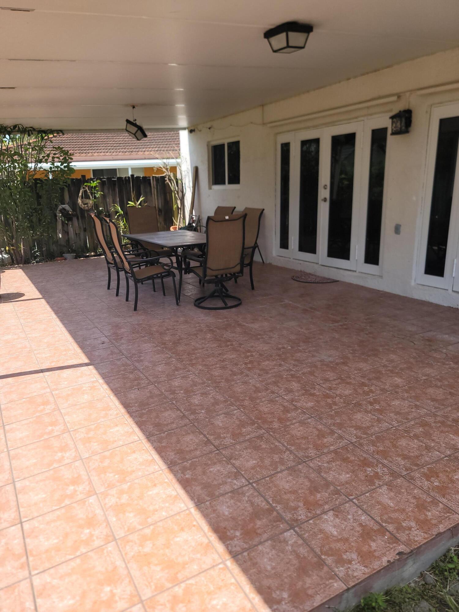 8448 Northwest 196th Terrace Hialeah, FL 33015 - Photo 30 of 67 a view of a patio with table and chairs and potted plants