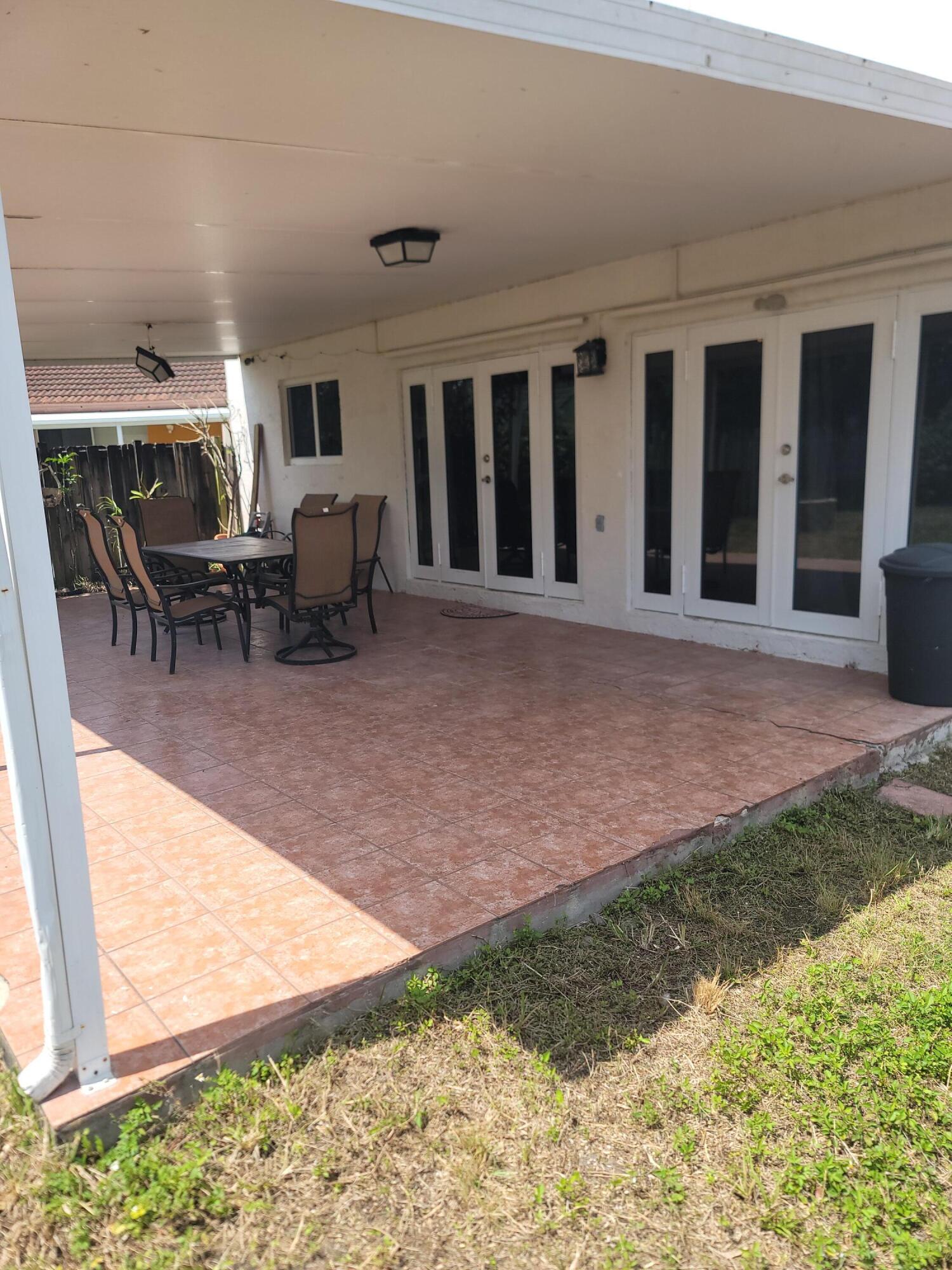 8448 Northwest 196th Terrace Hialeah, FL 33015 - Photo 31 of 67 a view of a porch with chairs and backyard