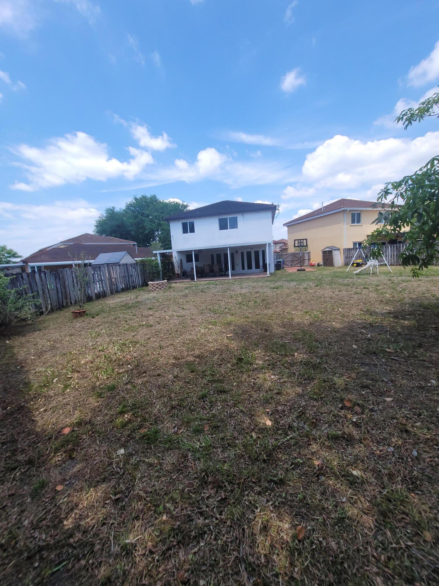 8448 Northwest 196th Terrace Hialeah, FL 33015 - Photo 40 of 67 a view of a big house with a big yard plants and large tree