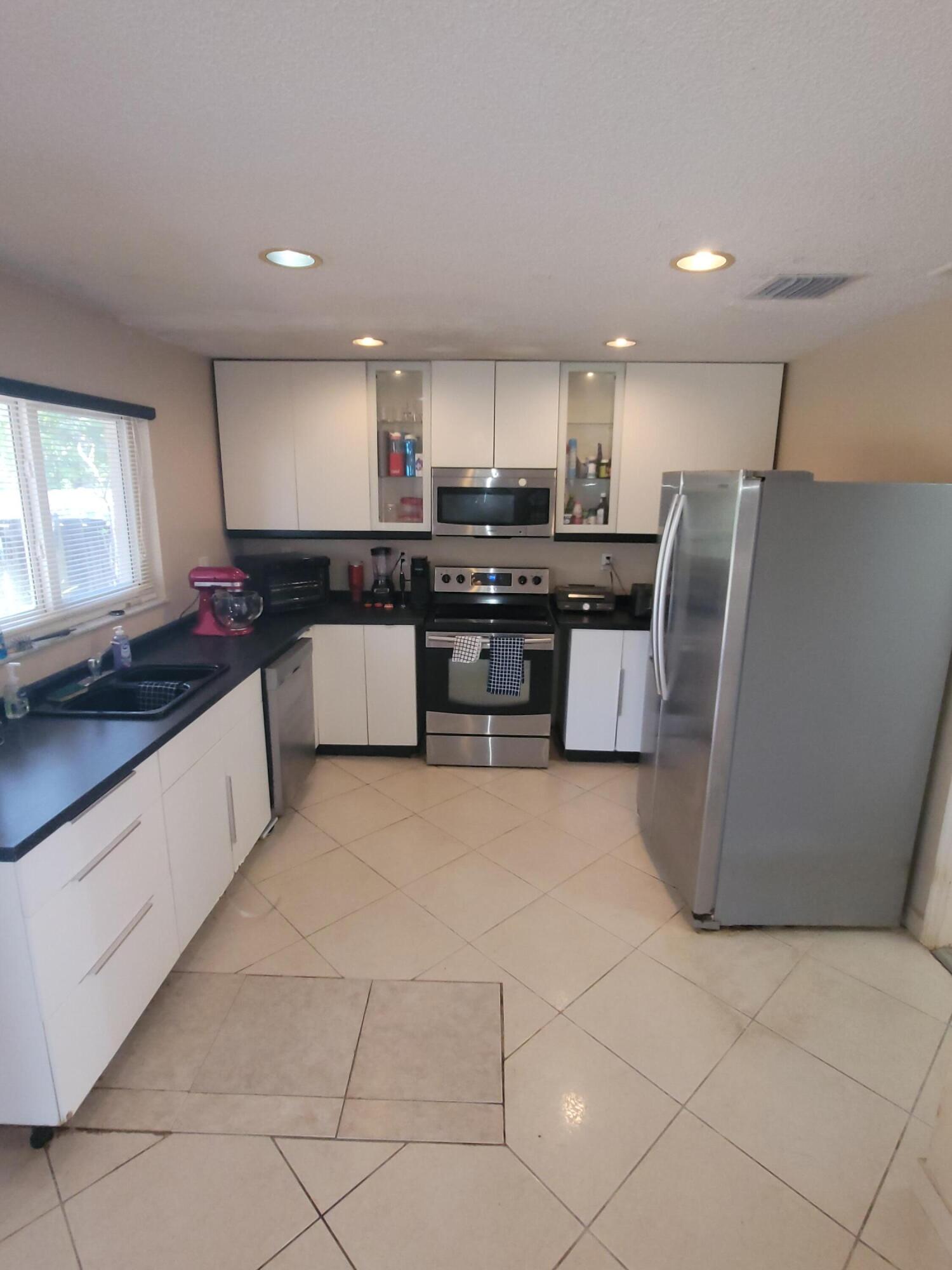 8448 Northwest 196th Terrace Hialeah, FL 33015 - Photo 9 of 67 a kitchen with stainless steel appliances a refrigerator sink and stove