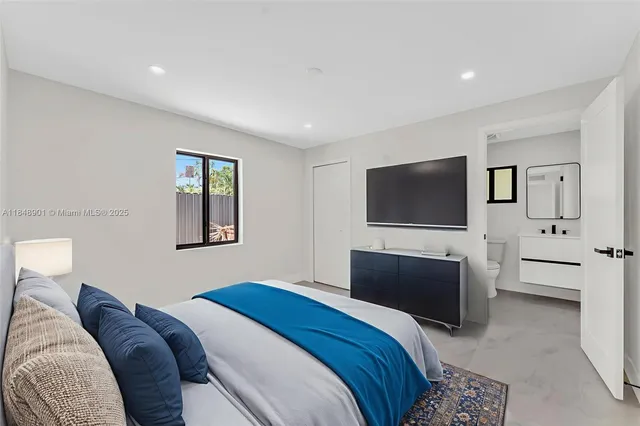 a bedroom with a bed and a flat screen tv