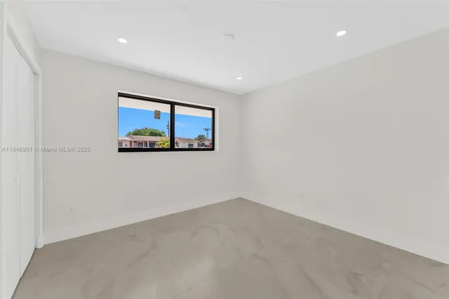 a bedroom with a large bed and a window