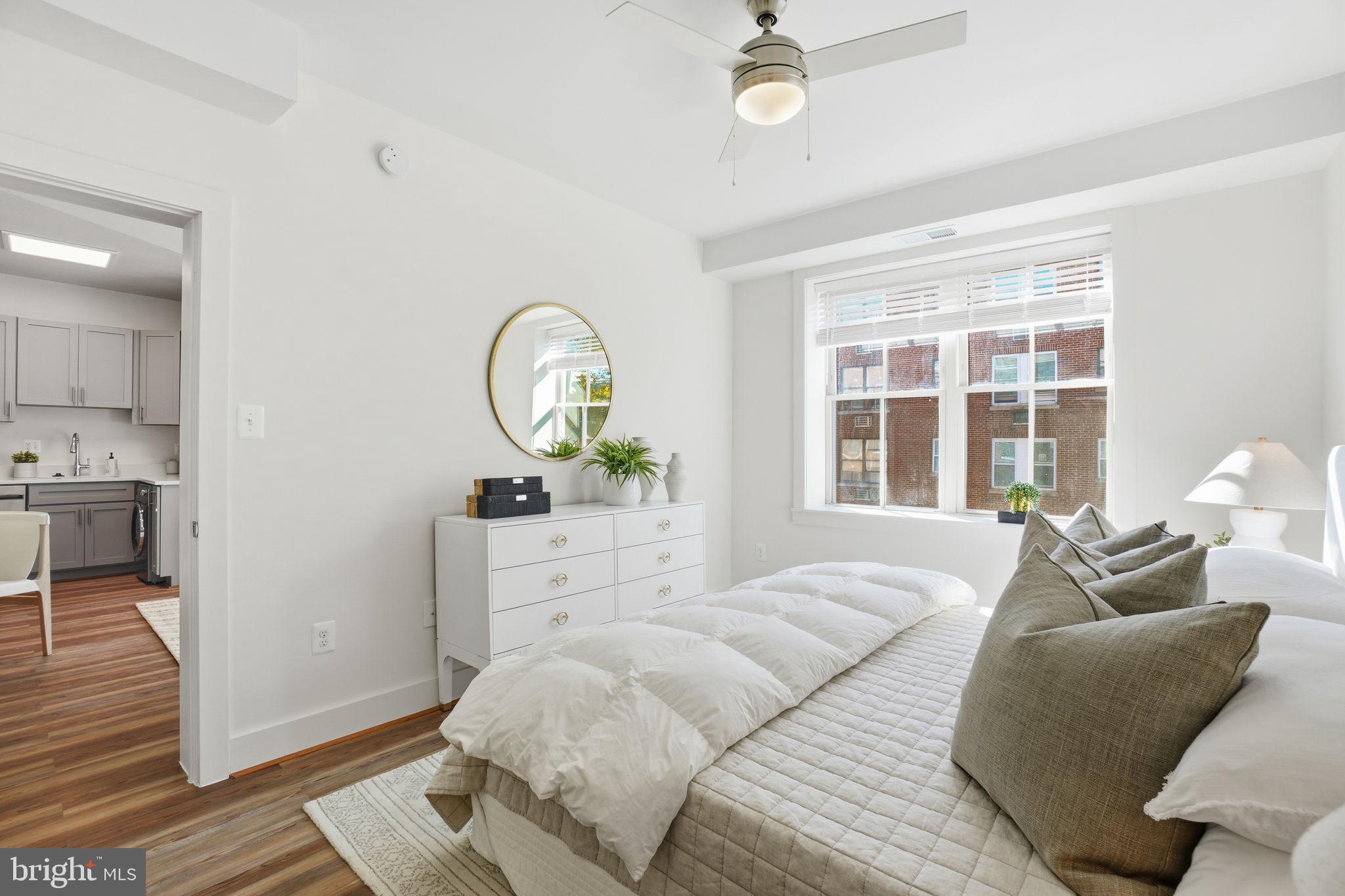 1451 Park Road Northwest, Unit 314 Washington, DC 20010 - Photo 16 of 22 a spacious bedroom with a bed a mirror and a large window