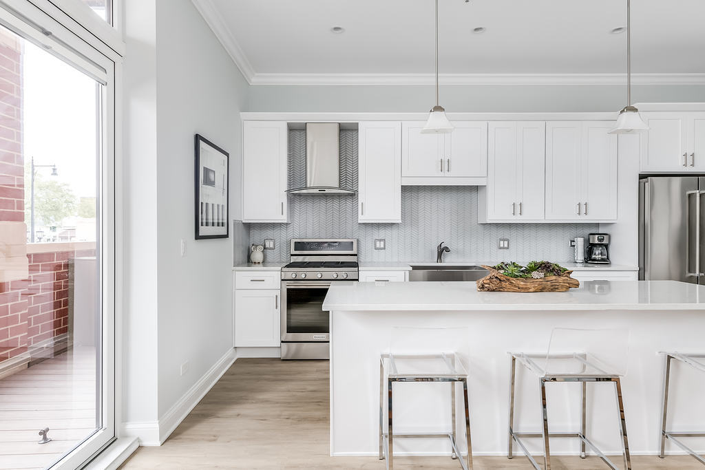 7652 Madison Street, Unit 304 Forest Park, IL 60130 - Photo 17 of 19 a kitchen with stainless steel appliances a white cabinets and wooden floor