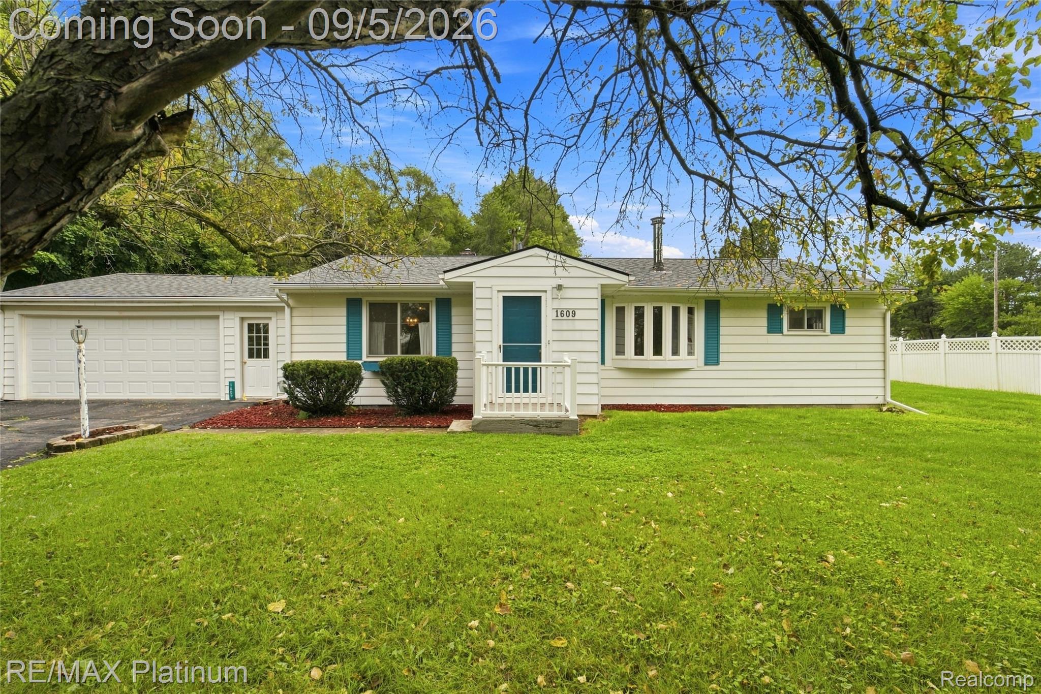 1609 West Dewey Road Owosso, MI 48867 - Photo 1 of 32 White siding exterior with a prominent bay window, attached garage, and a white picket fence